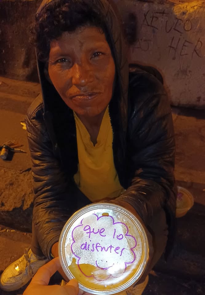 Una persona muestra una tapa de pote con el mensaje «que lo disfrutes» escrito con plumón