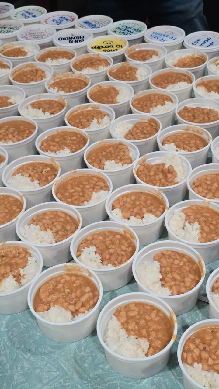 Vasos de espuma con frijoles y arroz listos para repartir, con mensajes en las tapas